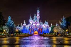 Château Disney illuminé la nuit représentant un séjour magique payé en chèques vacances